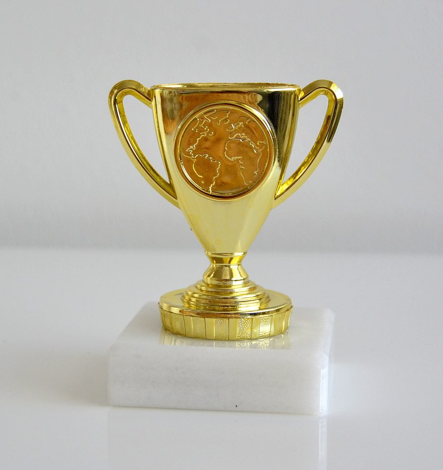 guldpokal trofé i guld med vit marmorsockel